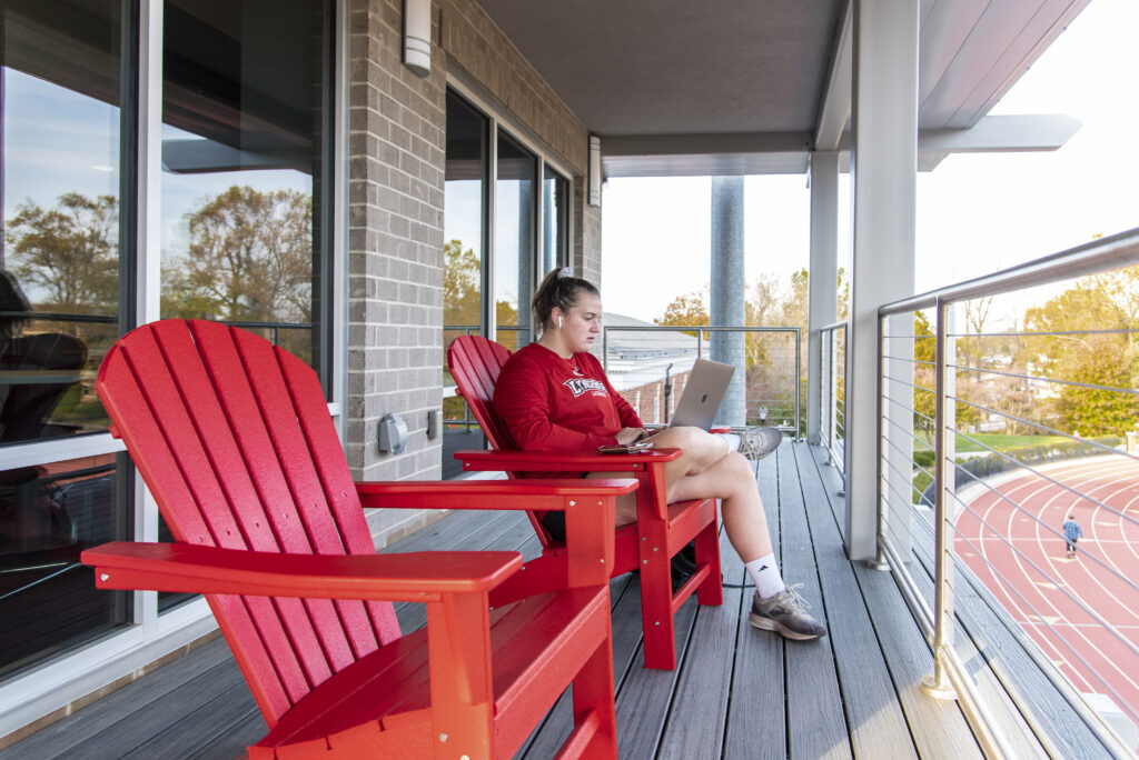 A female student sits in a red chair